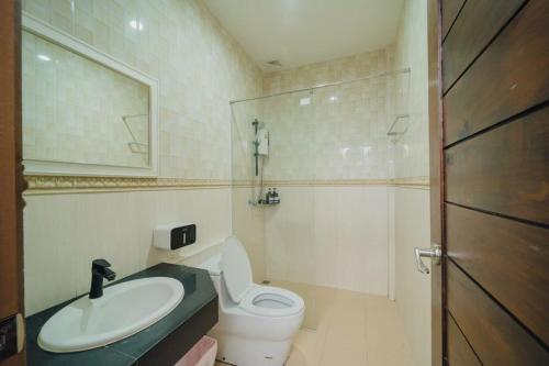 a bathroom with a toilet and a sink and a shower at Saline Hot Spring Resort นำ้พุร้อนเค็ม รีสอร์ท in Ban Nam Ron (1)