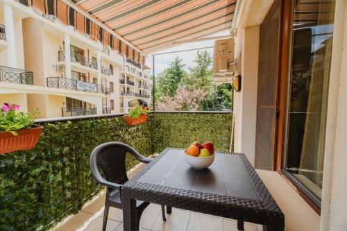 a table with a bowl of fruit on a balcony at Iglika Beach in Golden Sands