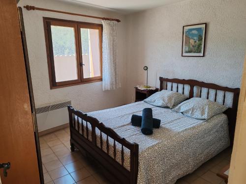 a bedroom with a bed with a blue hat on it at Auberge du Bourguet in Brenon