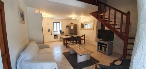 a living room with a couch and a tv and a table at CASA FOCI - maison T3 in Zonza