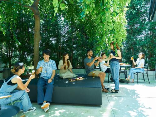 a group of people sitting on a bench eating at Piece Hostel Kyoto in Kyoto