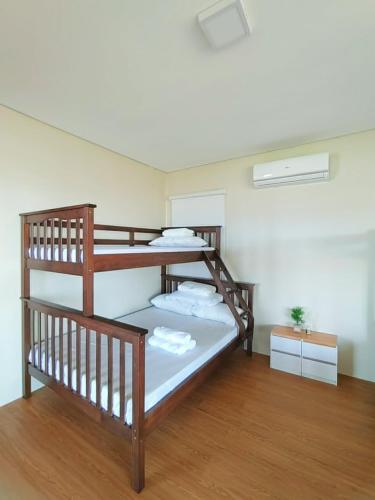 two bunk beds in a room with wood floors at The LakeFront Villa in Binangonan