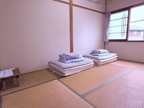 an empty room with two mattresses on the floor at Guest House Asahi in Otaru