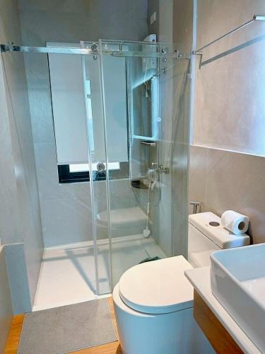 a bathroom with a shower with a toilet and a sink at The LakeFront Villa in Binangonan