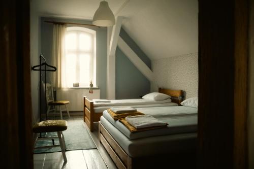 a bedroom with two beds and a window and a chair at Pokrzepka in Spychowo