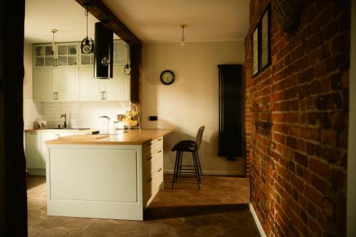 a kitchen with a counter and a brick wall at Pokrzepka in Spychowo