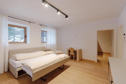 a white bedroom with a bed and a window at Appartamento Borésc - area wellness in Arabba