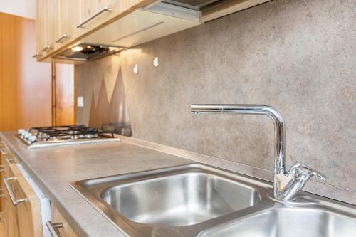 a kitchen with a sink and a stove at Appartamento Borésc - area wellness in Arabba