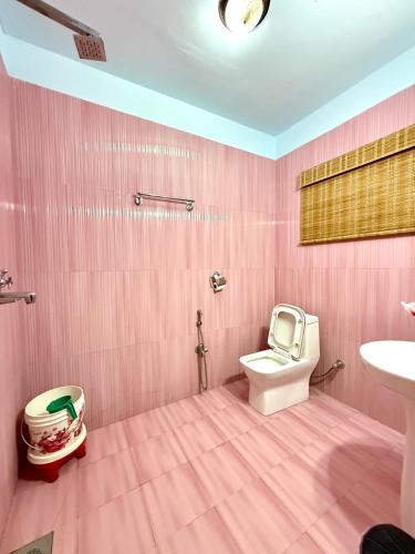 a pink bathroom with a toilet and a sink at Hotel Mantra and Adventure in Sauraha
