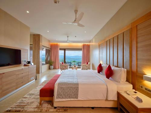 a bedroom with a large bed and a television at Vibe Munnar Resort & Spa in Munnar