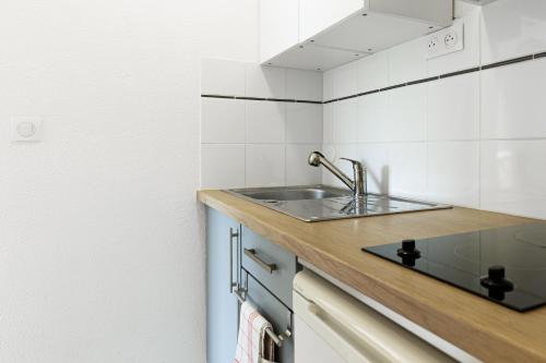 a kitchen with a sink and a counter at Appartement Les Jardins in Saint-Vincent-de-Tyrosse