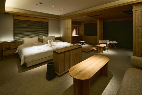 a hotel room with a bed and a table at Gion Kuromatsu in Kyoto
