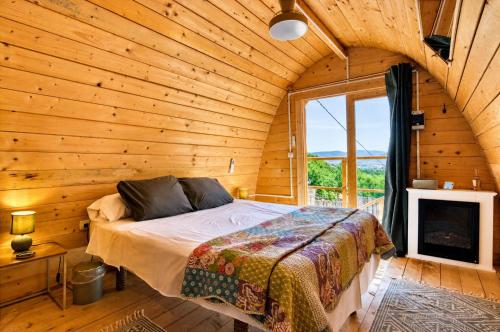a bedroom with a bed in a wooden room at Cabaña Massdepiedra in Sax