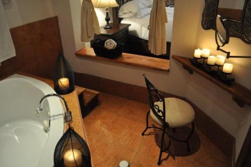 a bathroom with a sink and a bed with a mirror at Hotel Quinta Mision in Creel