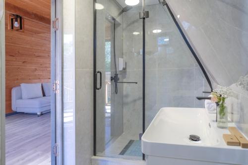a bathroom with a shower and a white sink at Tengri Village Karakol in Karakol