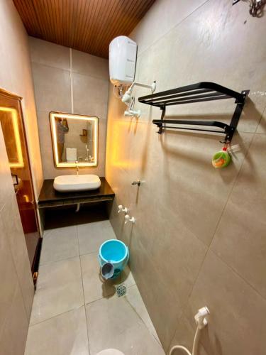 a bathroom with a sink and a mirror and a toilet at David Residency in Madurai