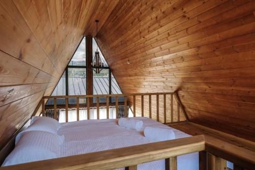 a bed in a room with a wooden wall at Tengri Village Karakol in Karakol
