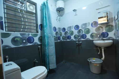 a bathroom with a toilet and a sink and a shower at SR Castle Gopalapuram in Chennai