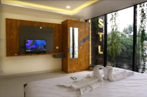a bedroom with two swans on a bed with a tv at SR Castle Gopalapuram in Chennai