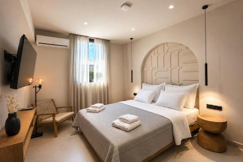 ein Schlafzimmer mit einem großen Bett und einem Fernseher in der Unterkunft Mageiras Boutique Hotel in Afytos