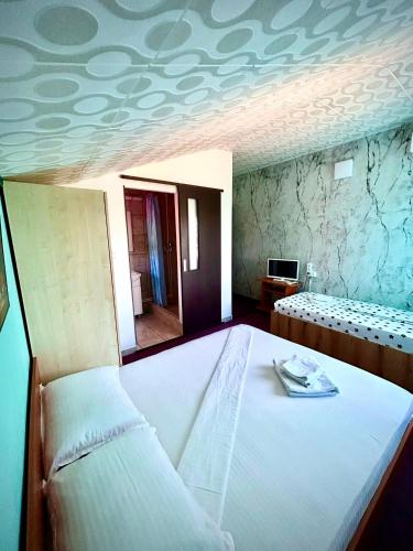 a bedroom with a bed and a tv in a room at Casa LariCris in Corbu