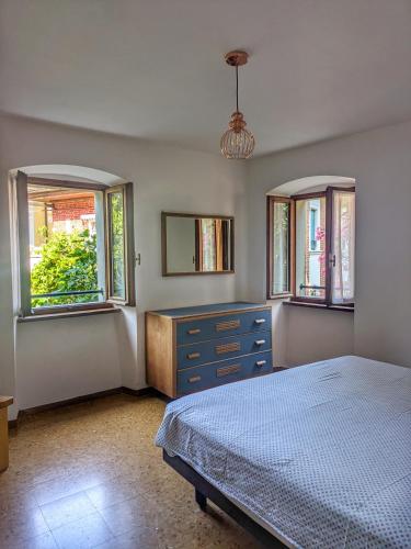 une chambre avec un lit, une commode et deux fenêtres dans l'établissement Casa Valle - Lago di Garda, à Brenzone