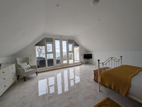 a bedroom with a bed and a chair in a room at Littlestairs in Shanklin