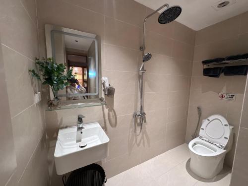 a bathroom with a toilet and a sink and a shower at Urban Nest in Hanoi