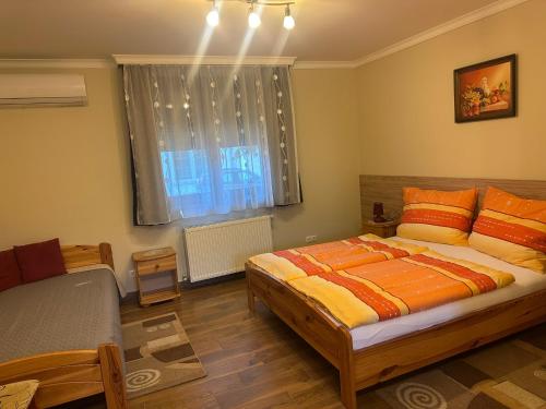 a bedroom with a large bed and a window at Furmint Vendégház in Tállya