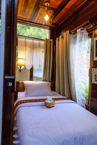 a bedroom with two beds and a window at Chom Wat Boutique Hotel in Ban Hau Chang