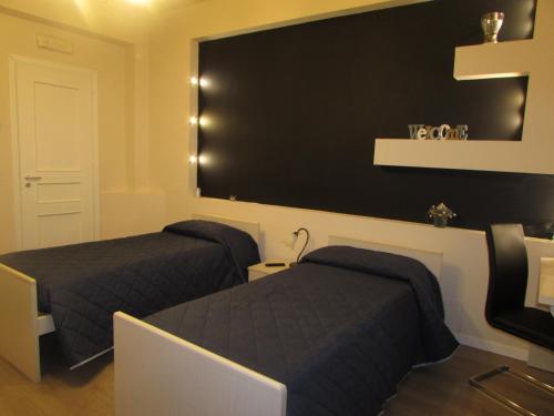a bedroom with two beds and a black wall at Crocco D'Oro in Caltavuturo