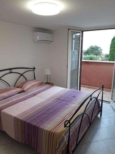 a bedroom with a bed and a large window at Bed & Breakfast La Volpe e L'Uva in Santa Marinella
