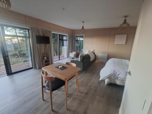 a bedroom with a bed and a table and a couch at Totaranui Accommodation Chalet 2 in Tata Islands