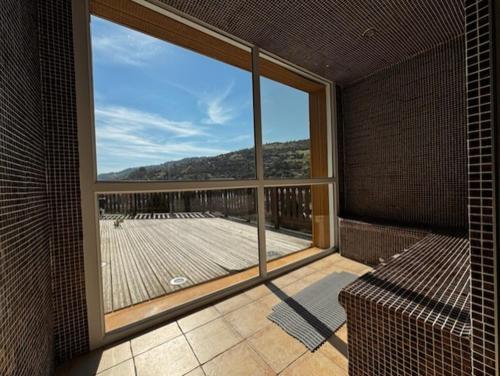 a large window in a room with a balcony at Hôtel Restaurant & Bien-être Le Chalet des Roches in La Bresse