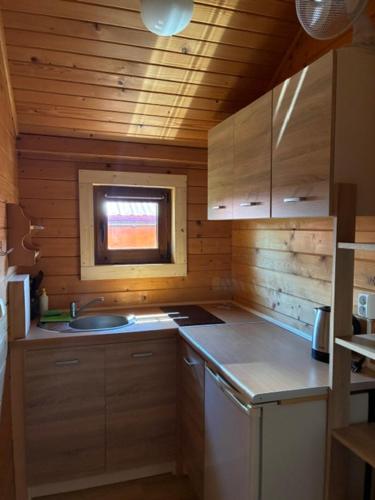 a small kitchen with a sink and a window at POD FALAMI - domki letniskowe in Polańczyk