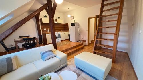 a living room with a white couch and a staircase at Apartmány v Žitě in Třeboň