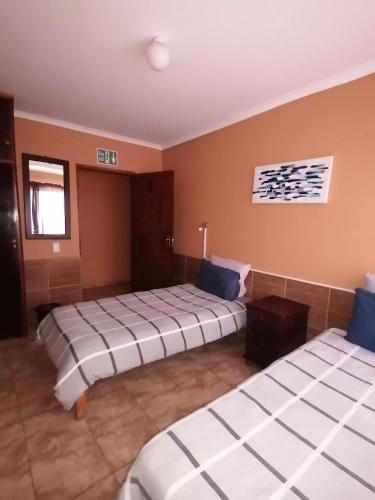 ein Zimmer mit zwei Betten in einem Zimmer in der Unterkunft Skippers Backpackers CC in Walvis Bay