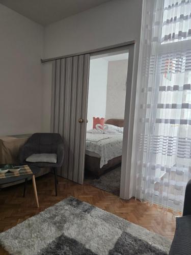 a living room with a bed and a window at Apartman Katarina in Sutomore