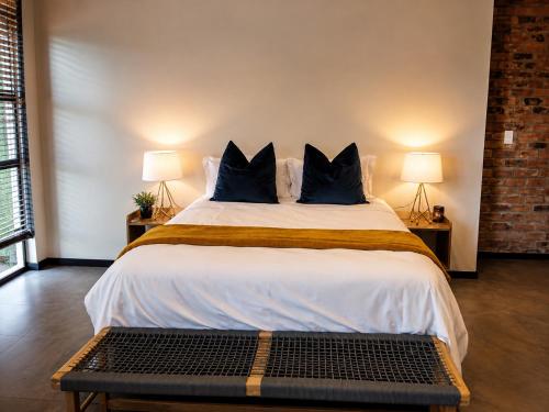 a bedroom with a large bed with blue pillows at Staynrestapartment in Nelspruit