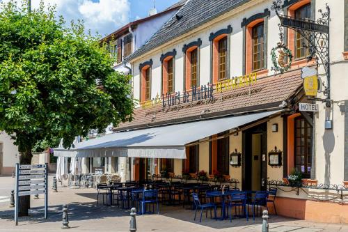restauracja z niebieskimi stołami i krzesłami przed budynkiem w obiekcie L'Ours de Mutzig - Hôtel Restaurant & Spa w mieście Mutzig