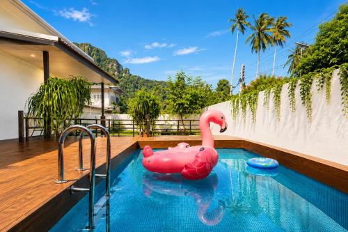 a swimming pool with a pink inflatable flamingo in a house at Nangkam Boutique Donsak in Ban Pheng Krong