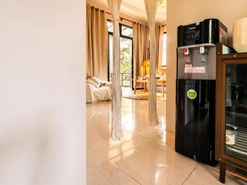 a kitchen with a black refrigerator and a living room at Casa Eden - Double King Bed - Peaceful Garden Retreat - 4K SmartTV in Thong Sala
