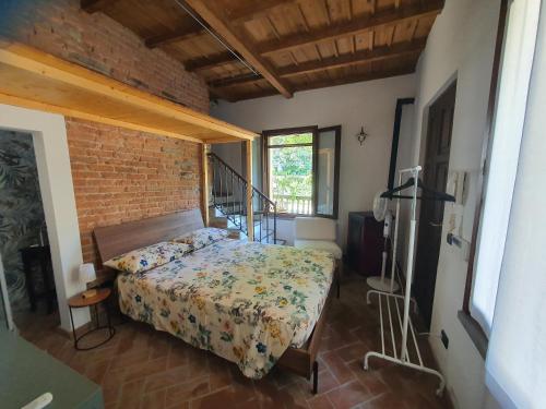 a bedroom with a bed and a brick wall at Collina del Milanese in San Colombano al Lambro