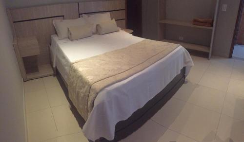 ein Schlafzimmer mit einem großen Bett mit weißer Bettwäsche und Kissen in der Unterkunft Barueri Premiêr Hotel in Barueri