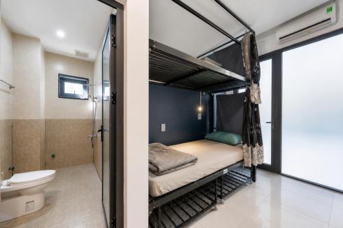 a bedroom with a bunk bed and a toilet at Two Horses Hostel in Hoi An