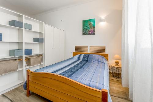 a small bedroom with a bed and shelves at Studio piscine Alpilles in Noves