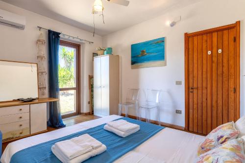 a bedroom with a bed with two towels on it at Casa 2 Punta Negra Vista Mare in Stintino