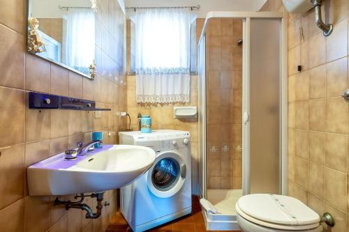 a bathroom with a washing machine and a sink at Casa 2 Punta Negra Vista Mare in Stintino