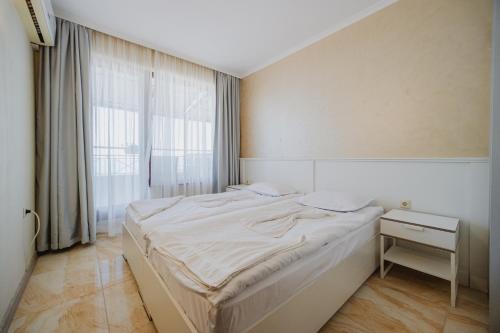 a bedroom with a large bed and a window at Seafront Apartment with Panoramic Terrace in Golden Sands