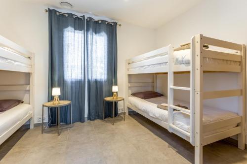 a bedroom with two bunk beds and two tables at Villa Hestia in Goudargues